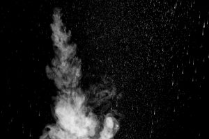 A jet of hot steam with splashes. The movement of hot steam with water droplets is highlighted